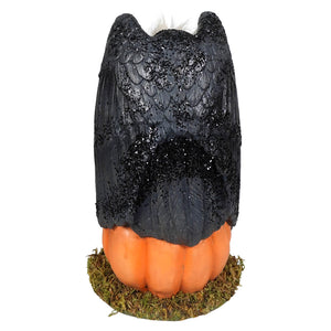 Black glittery owl figurine perched on an orange pumpkin base from treats for the buzzard collection