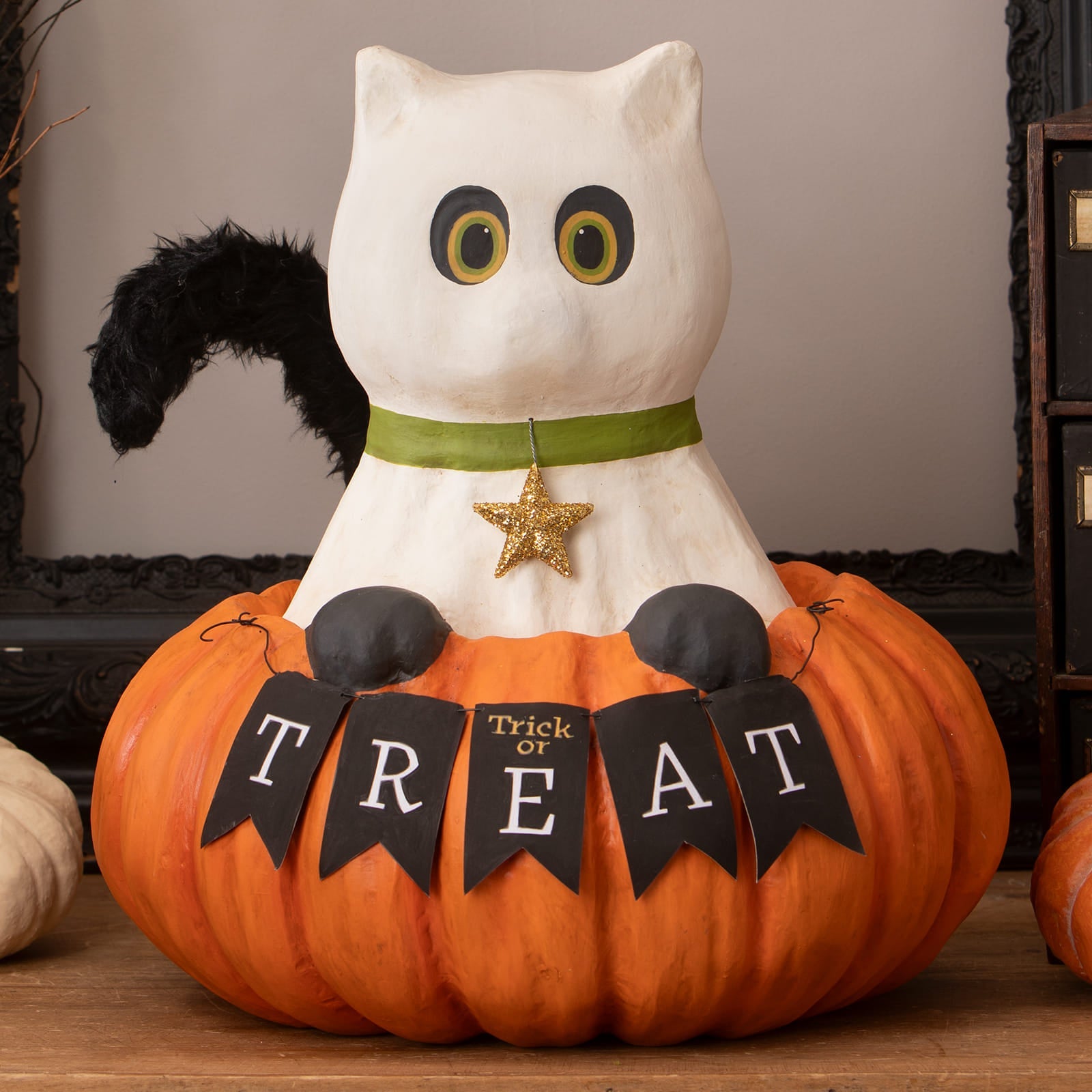 White ceramic halloween cats figurine named trick or treat casper with black feathered tail on pumpkin with banner
