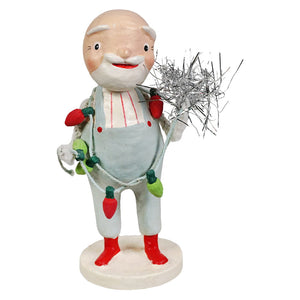 A cheerful balding figurine santa with white beard red shoes and festive string lights by bethany lowe designs