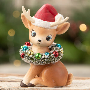 A tan resin bethany lowe design christmas reindeer figure wearing a red santa hat and festive wreath decor