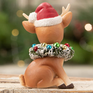 A charming brown resin christmas reindeer figure with santa hat and festive wreath by bethany lowe design