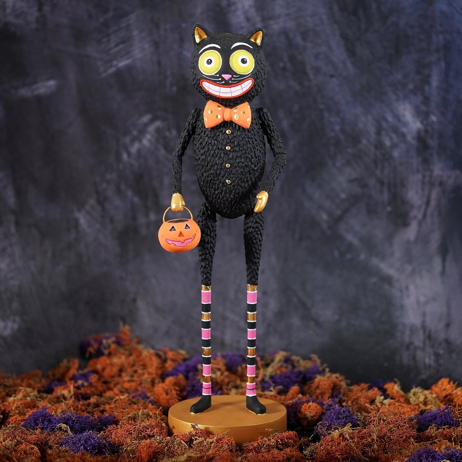 Crocheted black kook black cat with bright yellow eyes and orange bow tie holding a pumpkin lantern halloween cats decor