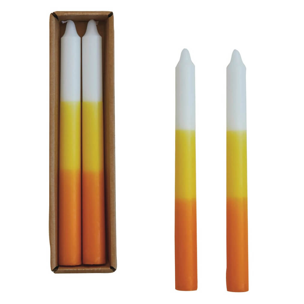 Tri-colored tapered candles with white, yellow, and orange sections.