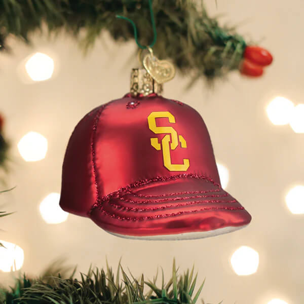 Glossy red usc baseball cap christmas glass ornament with gold sc logo and glittery stitching hanging on green string