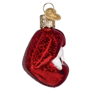 Vampire lips ornament is a glossy red glittery glass figural decor with white teeth and a gold heart tag