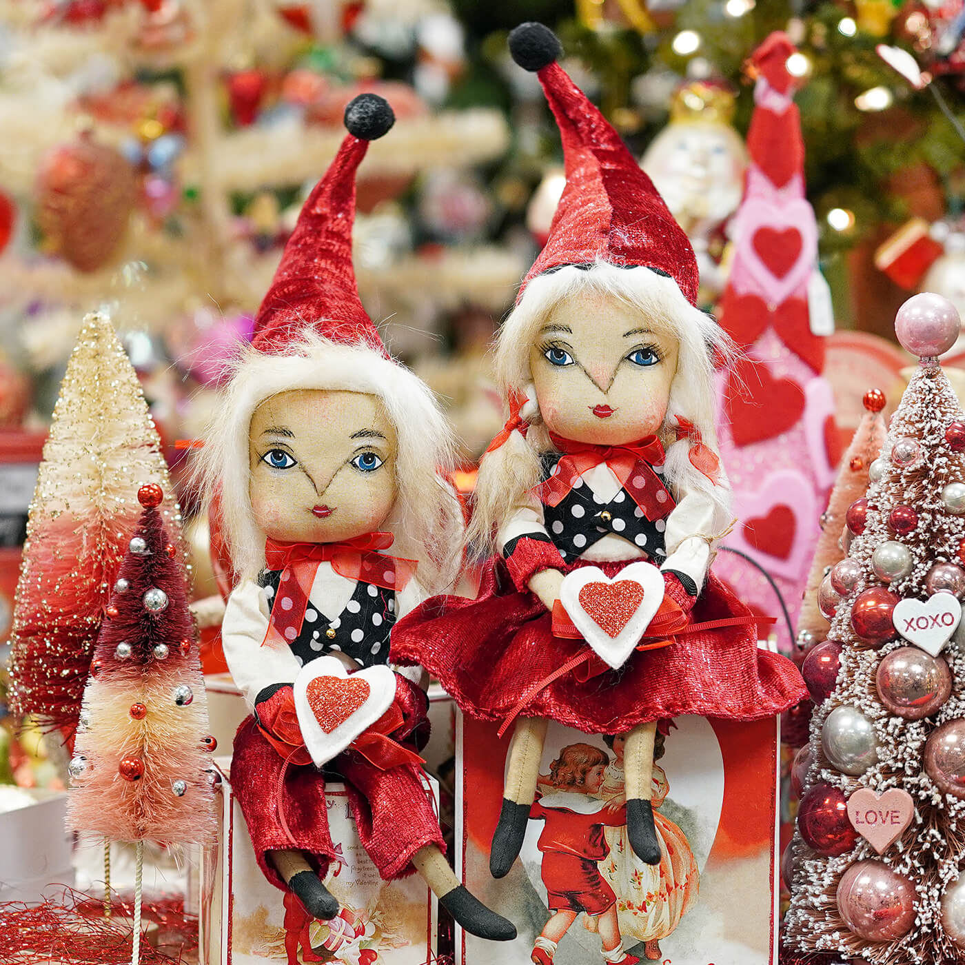 Two whimsical vander valentine valentine’s day dolls with red velvet hats and glittery outfits by joe spencer