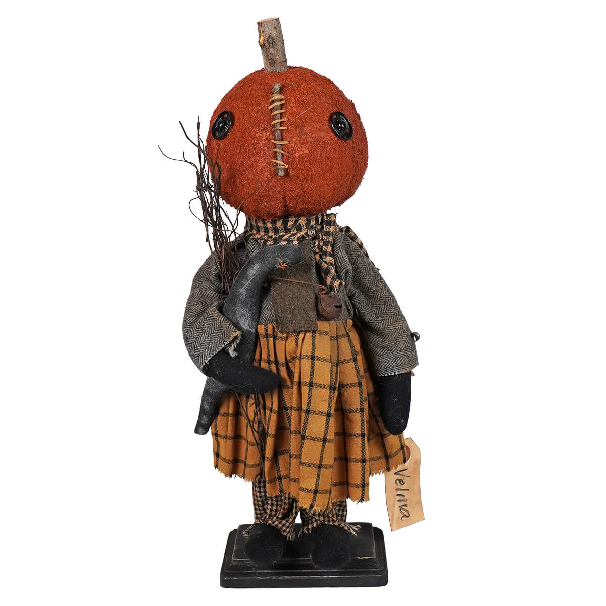 Handcrafted Halloween doll with a pumpkin head wearing a plaid skirt and gray sweater.