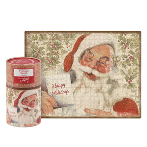 Vintage santa puzzle in a burlap textured cylindrical container with red label and santa holding happy holidays card