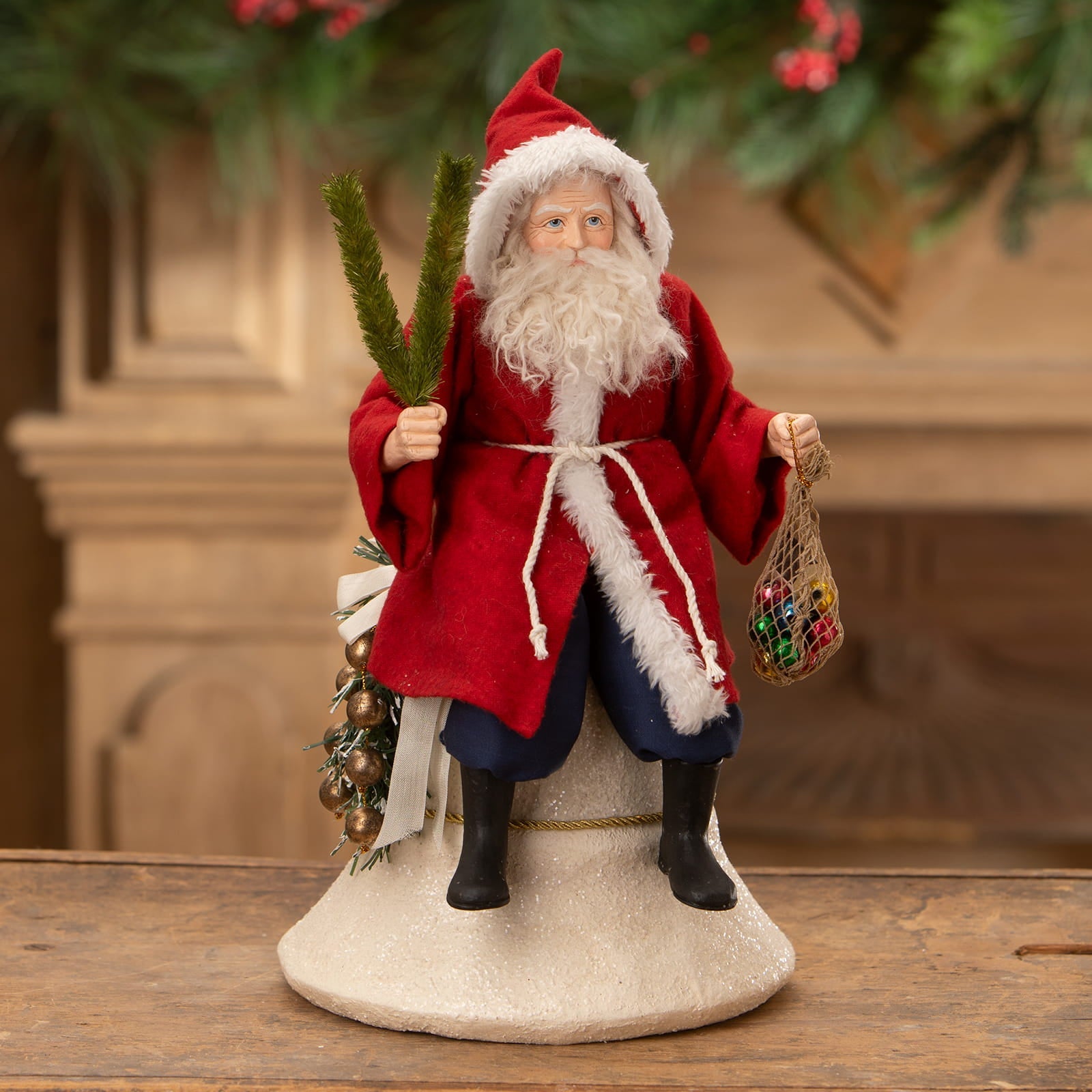 Vintage santa on bell red santa figure with white fur trim holding pine branch and mesh bag of colorful ornaments