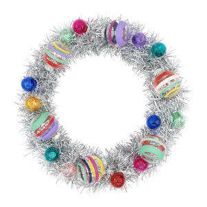Vivid vintage silver tinsel wreath decorated with colorful striped glass ornaments in red blue green purple and pink