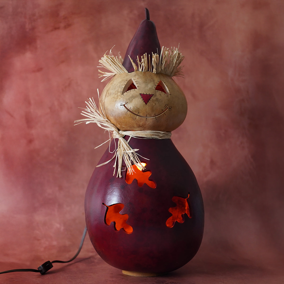 Extra large gourd carved dark red scarecrow lamp with pointed hat and straw scarf by meadowbrooke gourds