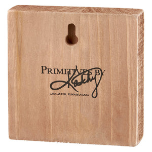 Wooden block with ’Primitives By’ text and Lancaster, Pennsylvania branding.