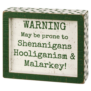 Green and white decorative box sign with humorous Irish-themed warning text about shenanigans, hooliganism and malarkey.