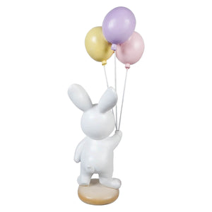 White bunny holding easter wishes balloons with three pastel-colored balloons on a white ceramic figurine