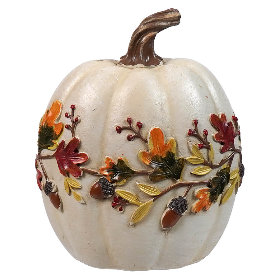 Decorative white ceramic pumpkin adorned with colorful autumn leaves and berries.