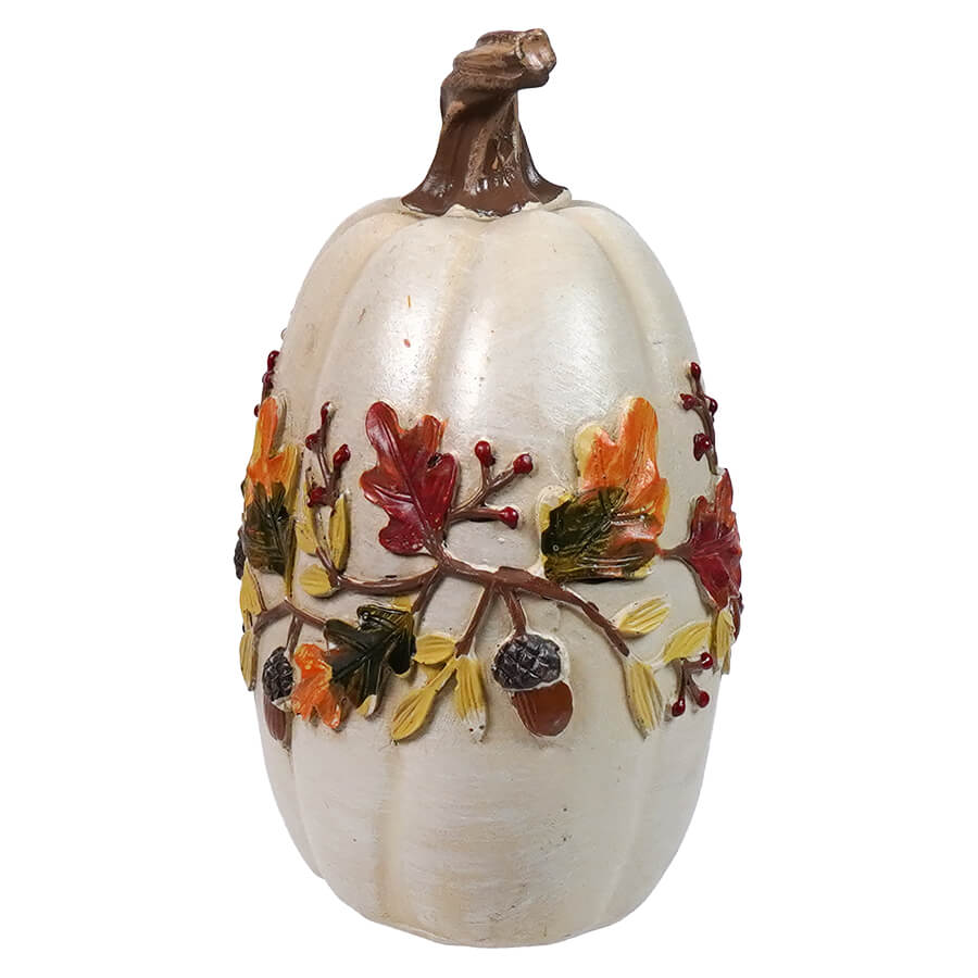 White decorative pumpkin with autumn-themed embellishments around its middle.