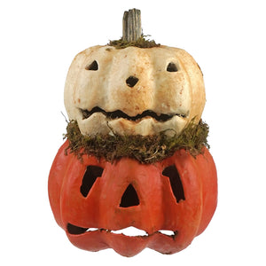 A rustic white and orange two layered carved pumpkin jack-o-lantern with spooky faces and mossy halloween pumpkins accents