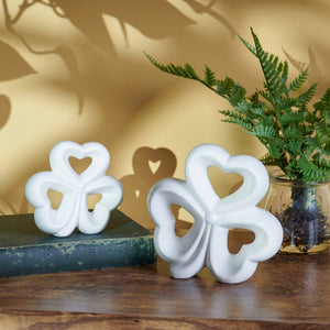 White ceramic shamrock decorations with heart-shaped cutouts.