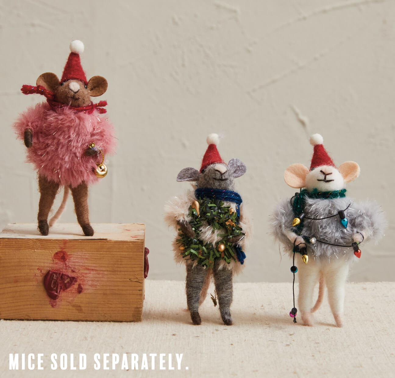 Three whimsical felt mice figurines wearing festive holiday attire and accessories.