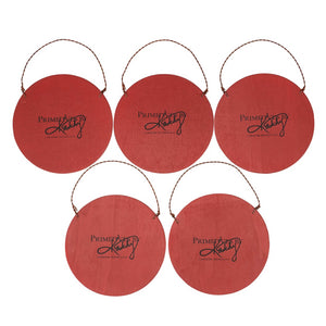 Red circular ornaments or decorations with ’Primitives by Kathy’ printed on them and wire hangers attached.