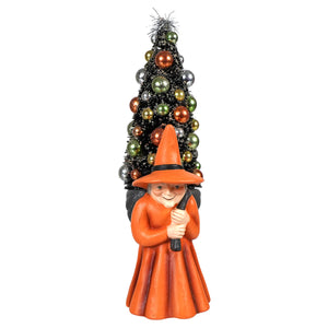Orange witch figurine carrying a tree perfect for halloween witches decor and spooky seasonal display