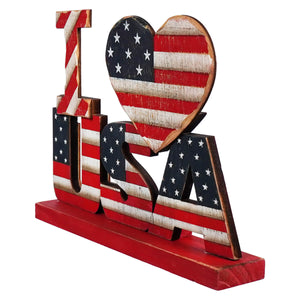 Decorative wooden ’USA’ letters with American flag design and heart shape on a red base.