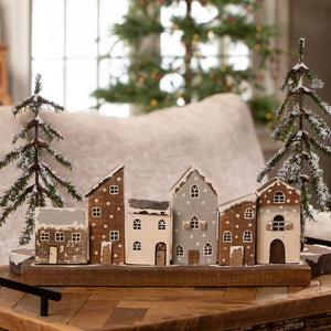 Rustic wooden village with vintage reproduction christmas village houses and snow-dusted evergreen trees in wood material