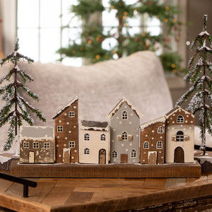 Rustic wooden village with snow-dusted vintage reproduction christmas village houses in brown gray and white finishes