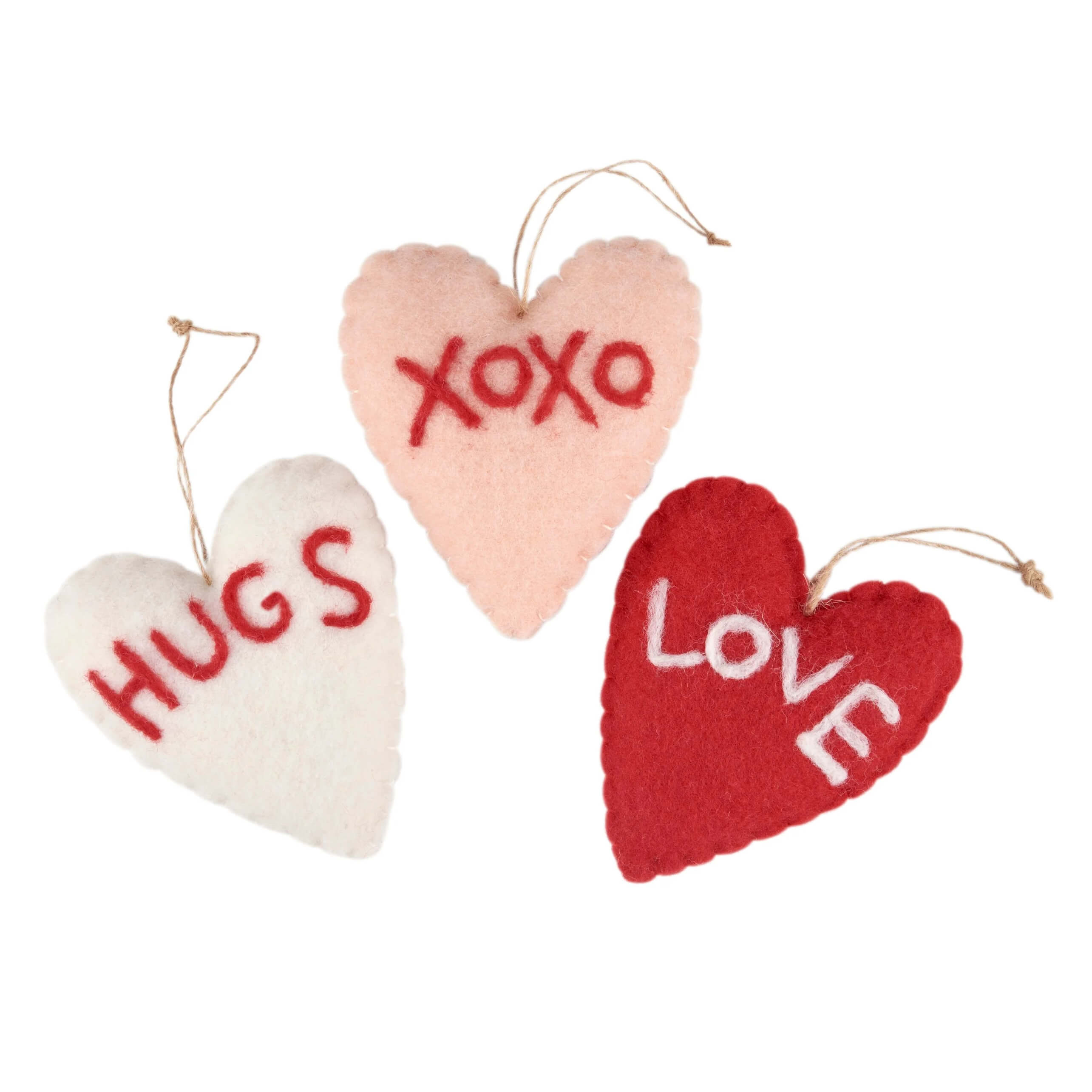 Three wool heart ornaments in white blush pink and red with hugs xoxo and love for valentine’s day decor