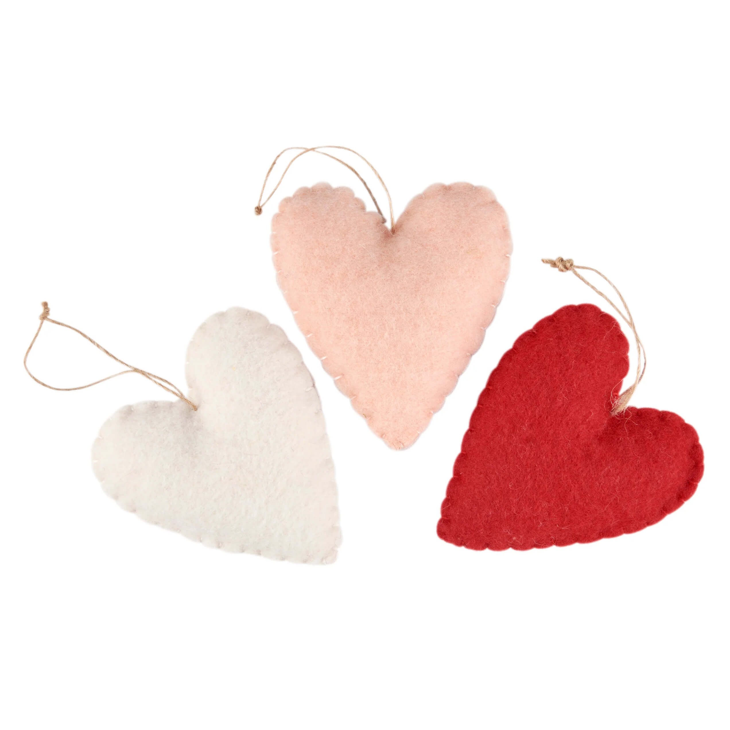 Three heart-shaped ornaments in white, pink, and red with hanging strings.