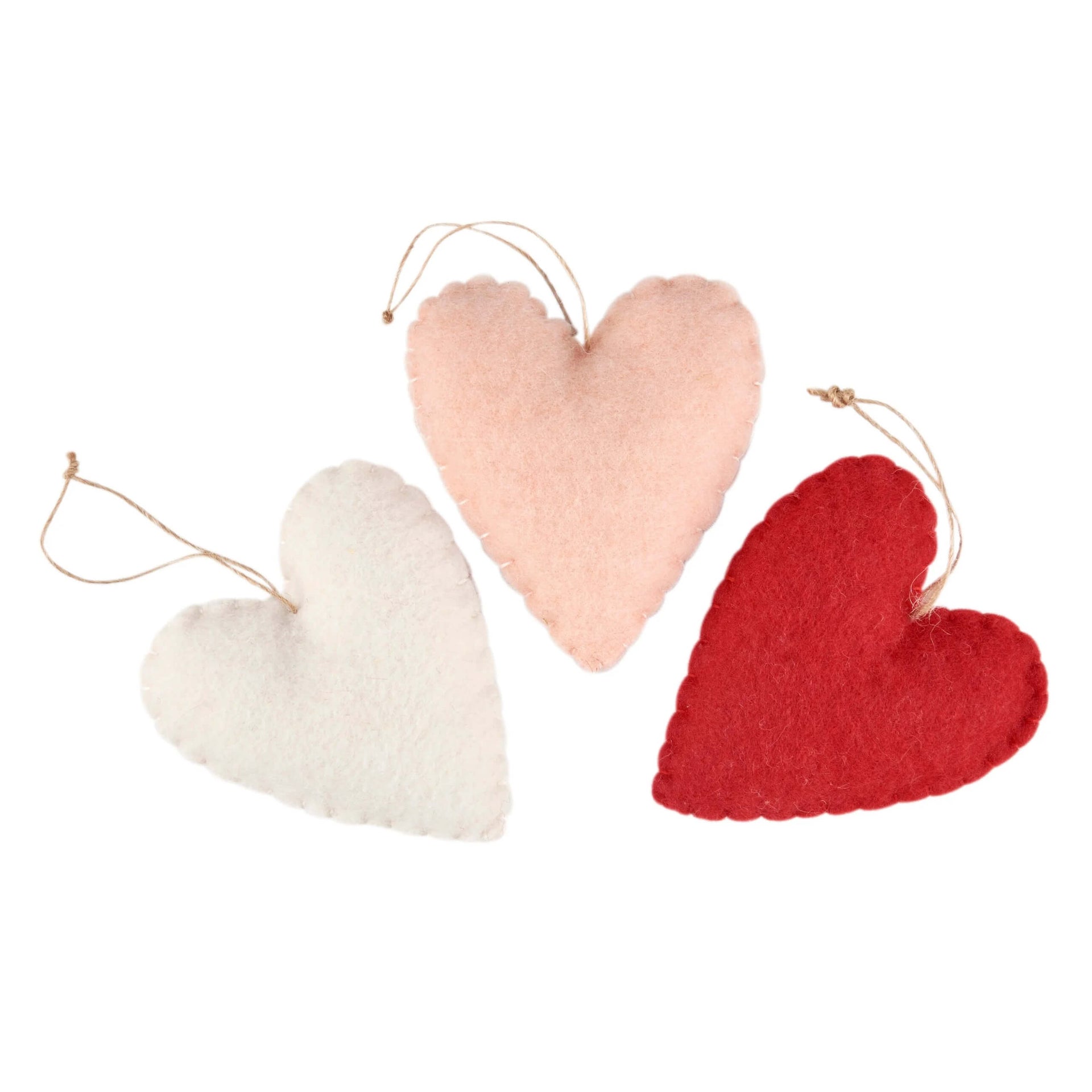Three xoxo wool heart ornaments in white blush pink and red with natural twine hangers perfect valentine’s day ornaments