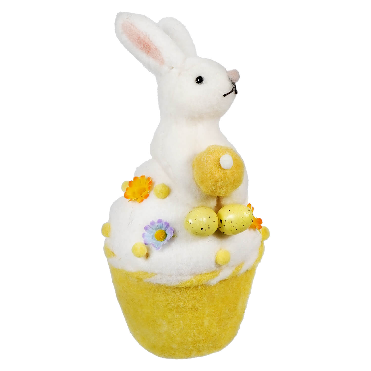 White bunny sitting atop a yellow cupcake decorated with flowers and chicks.