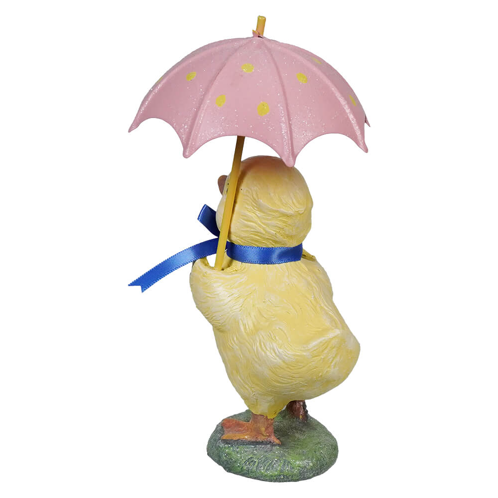 Yellow chick figurine holding pink umbrella with blue ribbon around its neck perfect for decoration