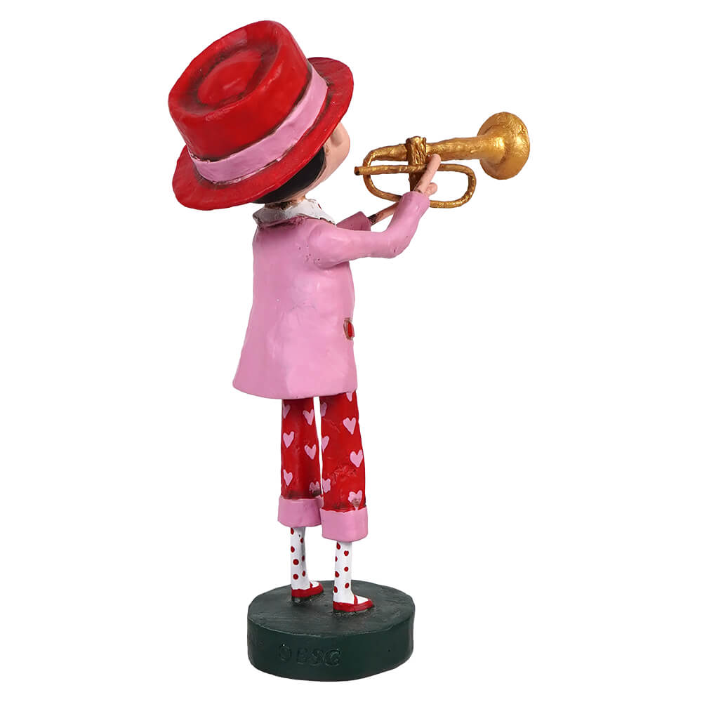 Decorative figurine of a trumpet player wearing a red hat, pink jacket, and heart-patterned pants.